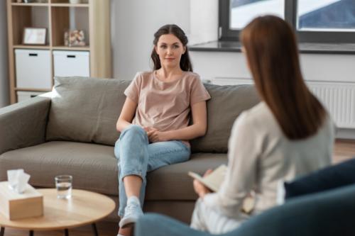 Woman sits on couch in individual therapy and talks about addiction issues